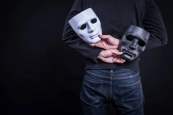 Hombre misterioso sosteniendo máscara en blanco y negro — Foto de Stock
