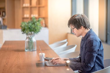 Dizüstü bilgisayar Office ile çalışan genç Asyalı adam