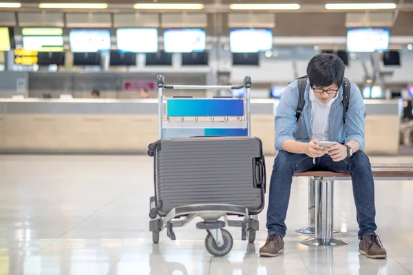 공항 체크인을 기다리는 젊은 아시아 남자 — 스톡 사진