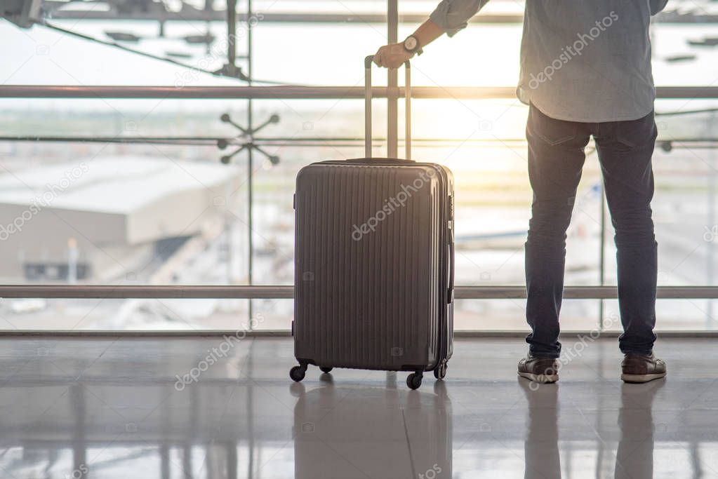 Young man with suitcase luggage in airport terminal