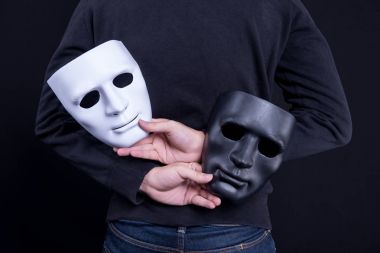 Mystery man holding black and white mask clipart