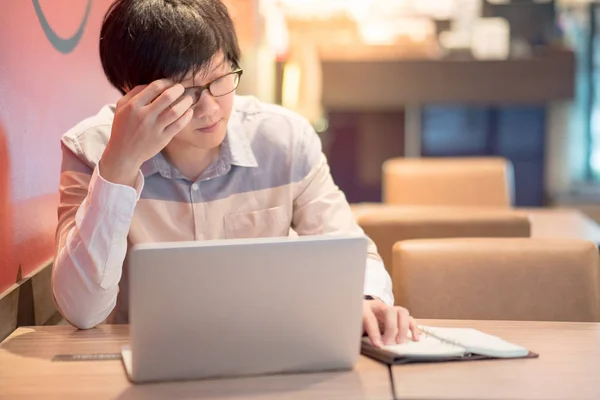 Ung asiatisk man känner du dig stressad under arbete — Stockfoto