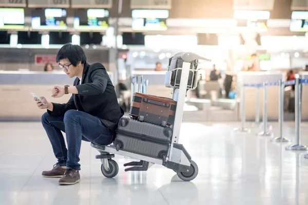 Joven asiático sentado en el carro en la terminal del aeropuerto — Foto de Stock