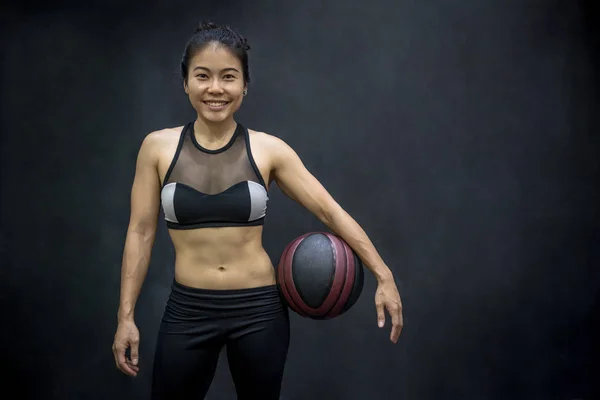 Молодая азиатка в спортивной форме проводит баскетбол — стоковое фото