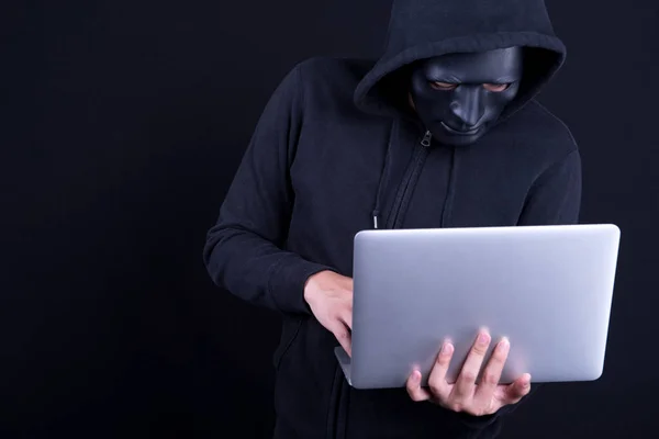 Mannelijke hacker met zwart masker uitvoering van laptop — Stockfoto