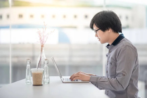Fiatal ázsiai üzletember kávézóban dolgozik — Stock Fotó