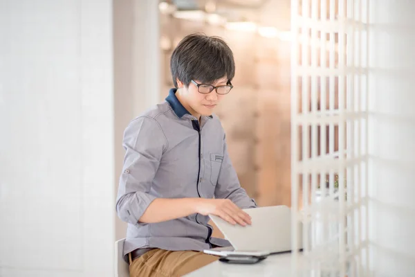 Giovane asiatico uomo working con laptop in cafe — Foto Stock