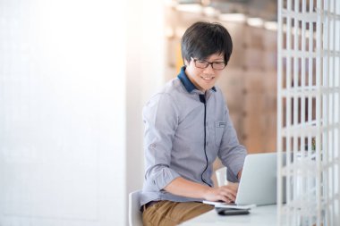 Genç Asyalı adam kafede dizüstü bilgisayar ile çalışma