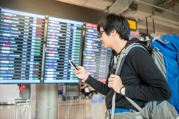 Genç Asyalı adam onun uçuş için kontrol sırt çantalı