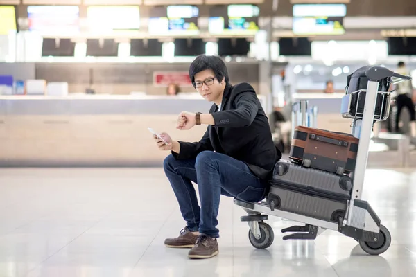 Joven asiático sentado en el carro en la terminal del aeropuerto — Foto de Stock