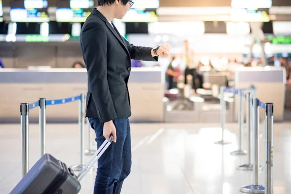 Havaalanında uçuş için bekleyen genç Asyalı adam