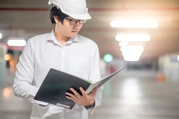 Fiatal ázsiai mérnök gazdaság fájlok építkezésen — Stock Fotó
