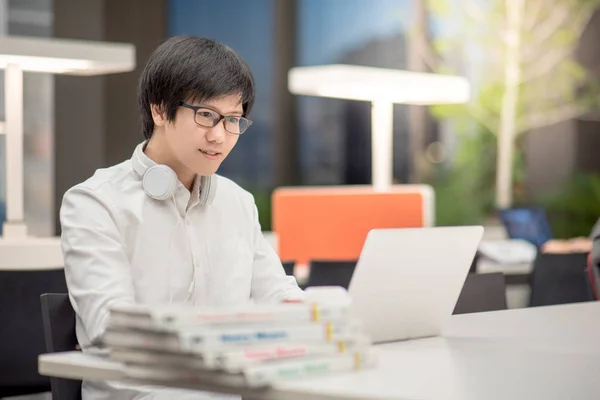 Ung asiatisk man universitetsstudent arbetar i biblioteket — Stockfoto