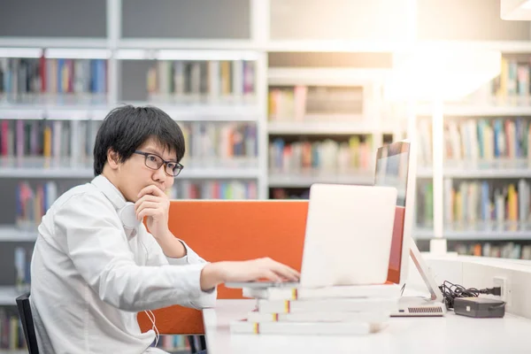 Jeune homme asiatique étudiant universitaire travaillant dans une bibliothèque — Photo