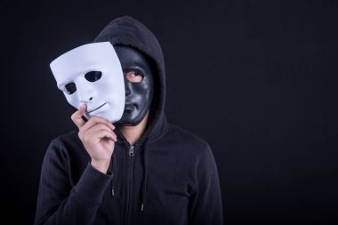 Gizemli adam beyaz maske tutan giyen siyah maske