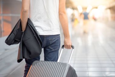 Takım elbise ve Bagaj içinde Havaalanı terminal tutan genç Asain adam