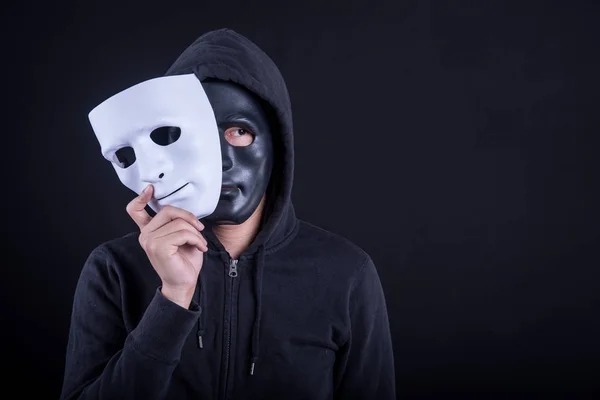 Geheimnisvoller Mann mit schwarzer Maske und weißer Maske. Anonyme soziale Maskierung oder Halloween-Konzept. — Stockbild Mysteriöser Mann mit schwarzer Maske und weißer Maske — Stockfoto