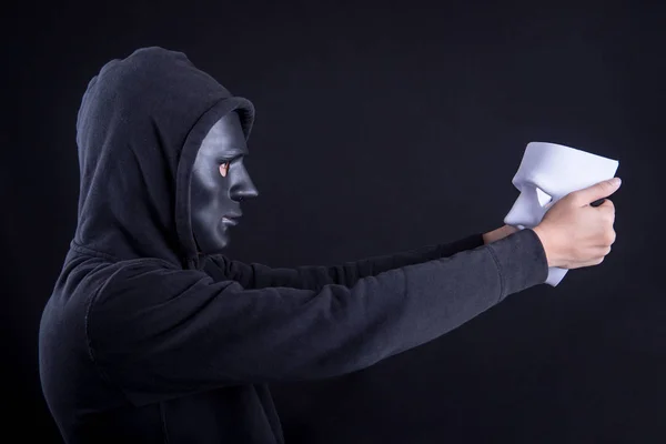 Mysterieuze man houden en kijken naar wit masker — Stockfoto