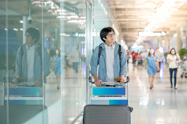 Asijský mladík s letiště vozík — Stock fotografie