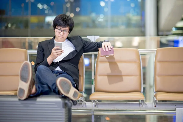 Jonge Aziatische zakenman gebruikend smartphone in de luchthaventerminal — Stockfoto
