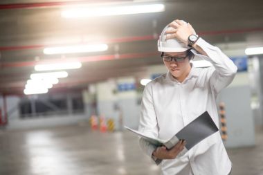 Genç Asyalı dosyaları inşaat alanında tutan mühendisi