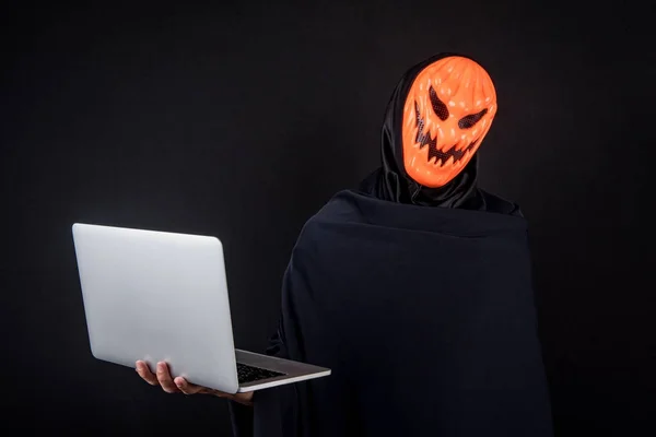 Hacker mit Halloween-Maske trägt Laptop — Stockfoto
