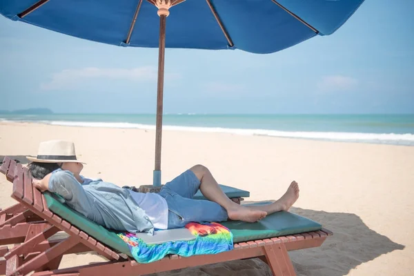 Tânăr Asain om culcat pe bancă de plajă — Fotografie, imagine de stoc