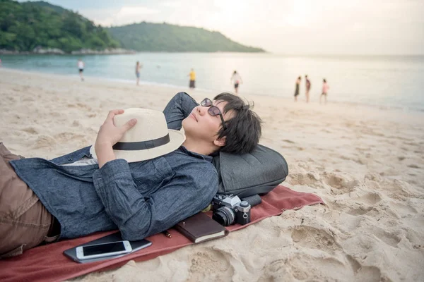 young Asian man lying on the beach