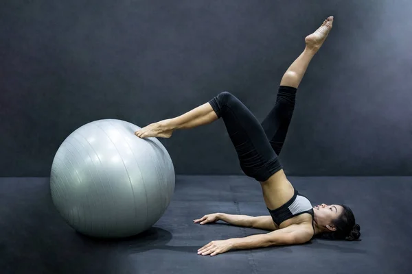 Молодая азиатская спортсменка делает упражнения на пилатесе с упражнениями — стоковое фото