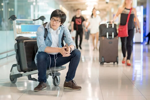 Arabası Havaalanı terminal üzerinde oturan genç Asyalı adam — Stok fotoğraf