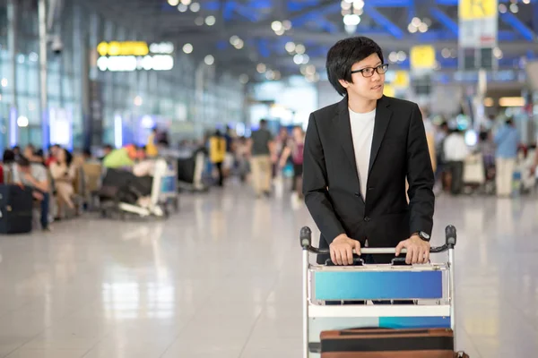 Young asian man with luggage in airport terminal