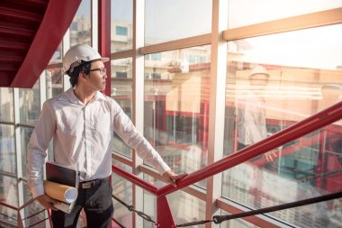 Genç Asyalı dosyaları inşaat alanında tutan mühendisi