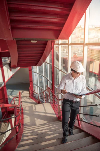 Young Asian Engineer holding files at construction site — Stock Photo, Image