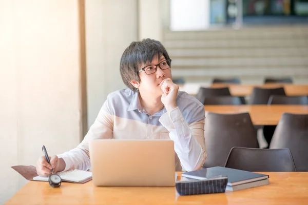 Ung asiatisk man arbetar med laptop i college — Stockfoto