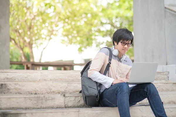 Ung asiatisk man universitetsstudent sitter på trappan — Stockfoto