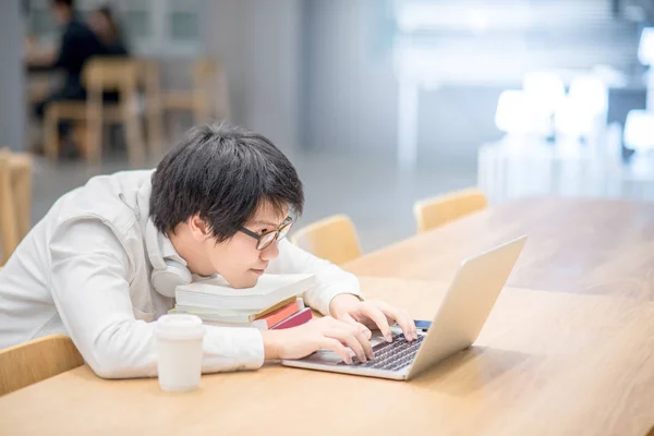 Jovem asiático estudante universitário fazendo lição de casa — Fotografia de Stock