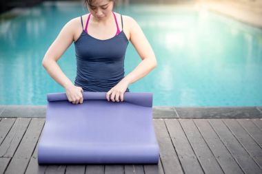Genç Asyalı kadın Yoga mat Yüzme Havuzu haddeleme