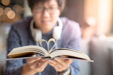 Genç adam kitap kalp şekil sayfası katlanmış