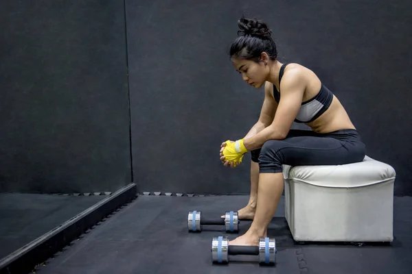 Jonge Aziatische vrouw zitten in de buurt van halters sport — Stockfoto