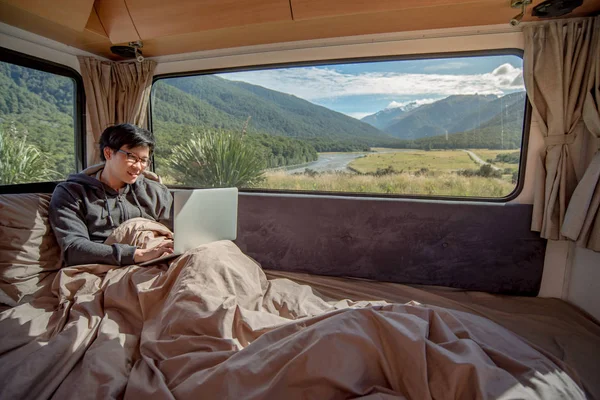 Joven hombre asiático trabajando con el ordenador portátil en autocaravana van — Foto de Stock