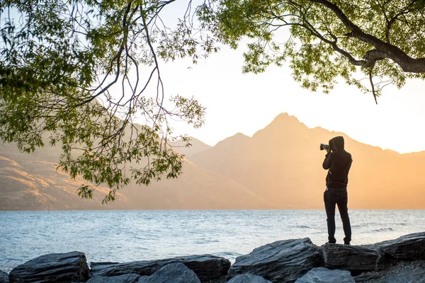 Fiatal férfi fotós bevétel fénykép során naplemente Queenstown — Stock Fotó