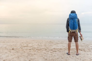 Genç Asyalı backpacker sahilde duran