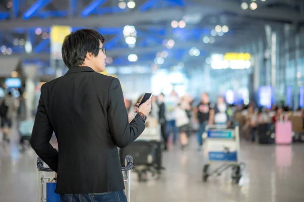 공항 터미널에 스마트폰 사용 하는 젊은 아시아 남자 — 스톡 사진