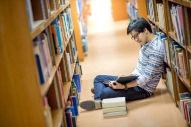 Genç Asyalı adam Üniversitesi Öğrenci okuma kitabı Kitaplığı'nda