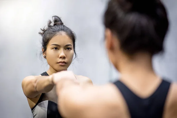 Молодые азиатские атлетичные женщины в спортивной форме ударяя — стоковое фото
