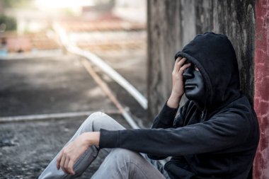 Gizemli adam siyah maske duygu ile abandone içinde oturan vurguladı