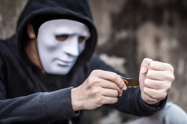 Mysterieuze man in wit masker proberen te snijden zijn pols met de puin-o — Stockfoto