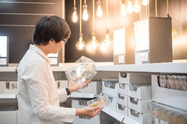 Young Asian man shopping electrical light bulb — Stock Photo, Image