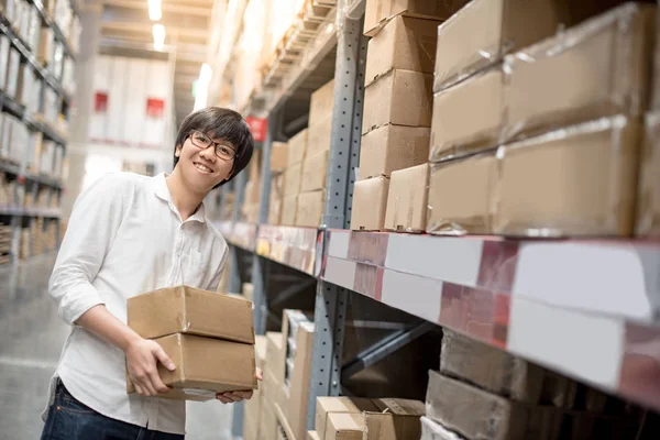 Ung asiatisk man redovisade papper lådor i lager — Stockfoto