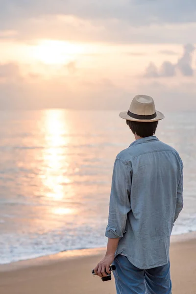 Tineri asiatic om călător în căutarea apus de soare la plaja tropicală — Fotografie, imagine de stoc